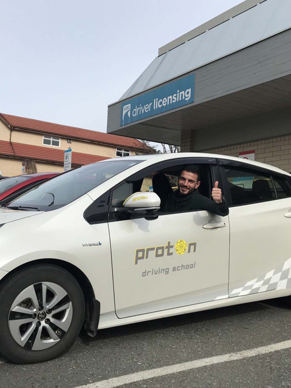 student in driver seat with thumb up